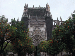 The east side of the Seville Cathedral with the Puerta de la Concepción gate and orange trees at the Patio de los Naranjos courtyard