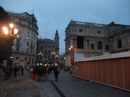 Southeast side of the Casa Consistorial de Sevilla building and horses and carriages at the Avenida de la Constitución avenue