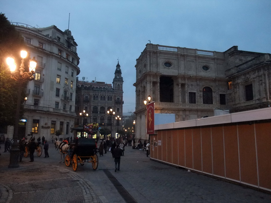 Southeast side of the Casa Consistorial de Sevilla building and horses and carriages at the Avenida de la Constitución avenue