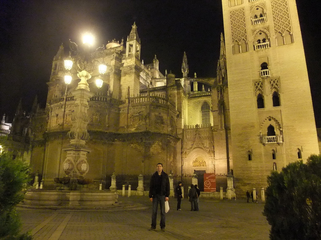 Tim at the east side of the Seville Cathedral with the Giralda tower at the Plaza del Triunfo square, by night