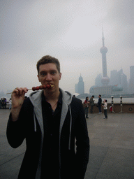 Tim eating candy, Huangpu river and the skyline of the Pudong district, with the Oriental Pearl Tower