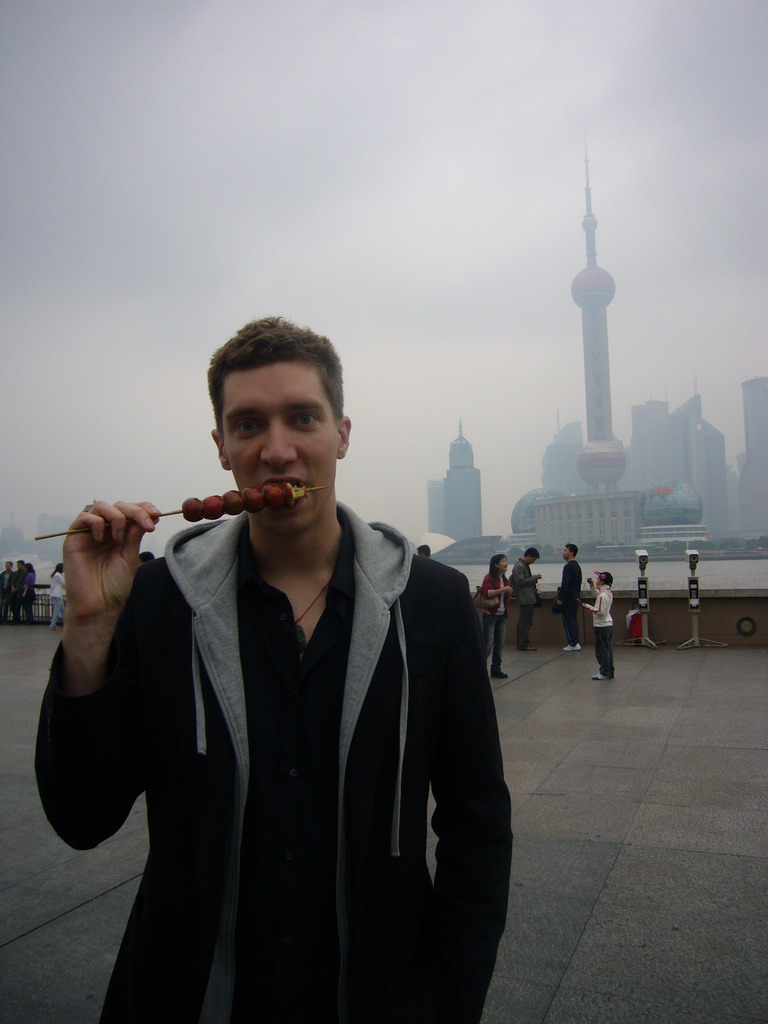 Tim eating candy, Huangpu river and the skyline of the Pudong district, with the Oriental Pearl Tower