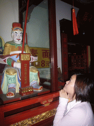 Miaomiao with a statue in the Temple of the Town Gods in the Old Town