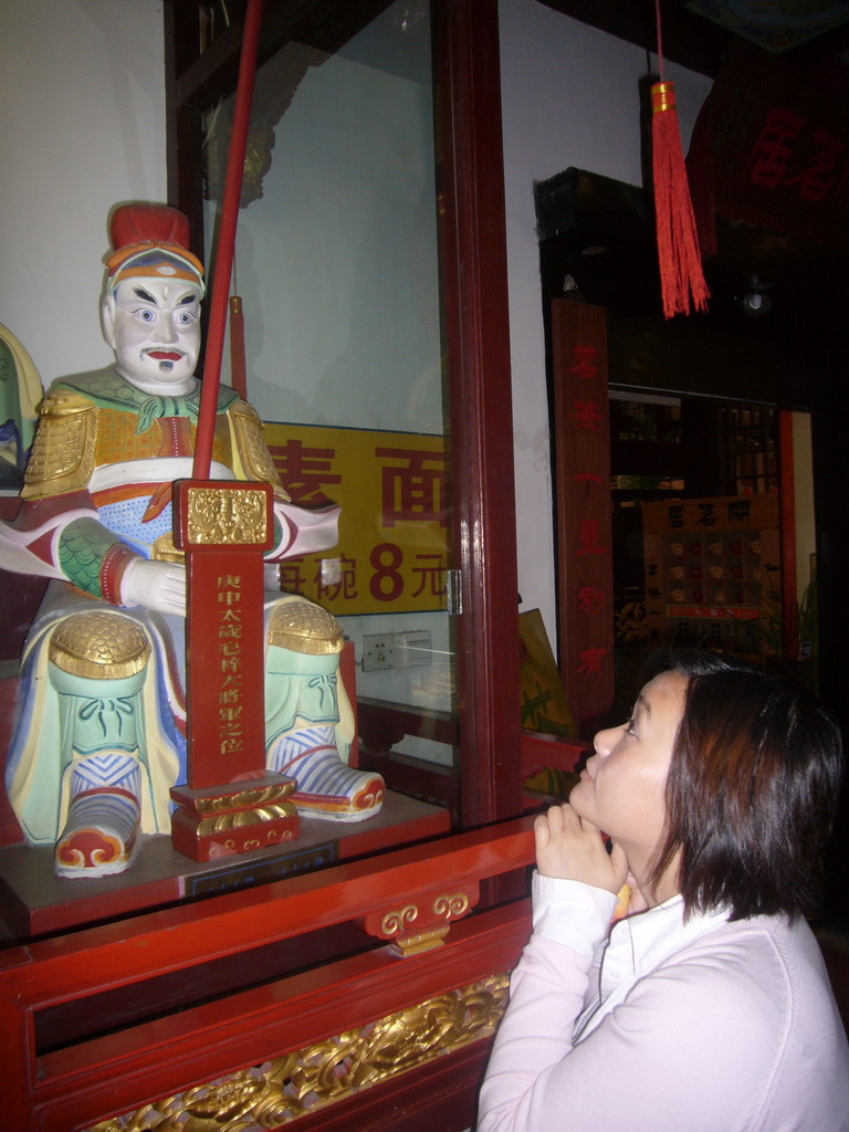 Miaomiao with a statue in the Temple of the Town Gods in the Old Town