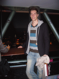 Tim at the top of the Oriental Pearl Tower, with a view on the Puxi skyline with the Guang Ming Building, by night