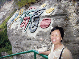 Miaomiao`s mother at inscriptions in a local language, at Tiger Leaping Gorge