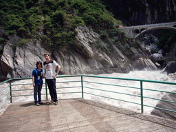 Tim and Miaomiao at the rapids and bridge at Tiger Leaping Gorge