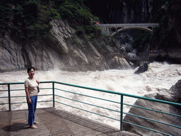Miaomiao`s mother at the rapids and bridge at Tiger Leaping Gorge