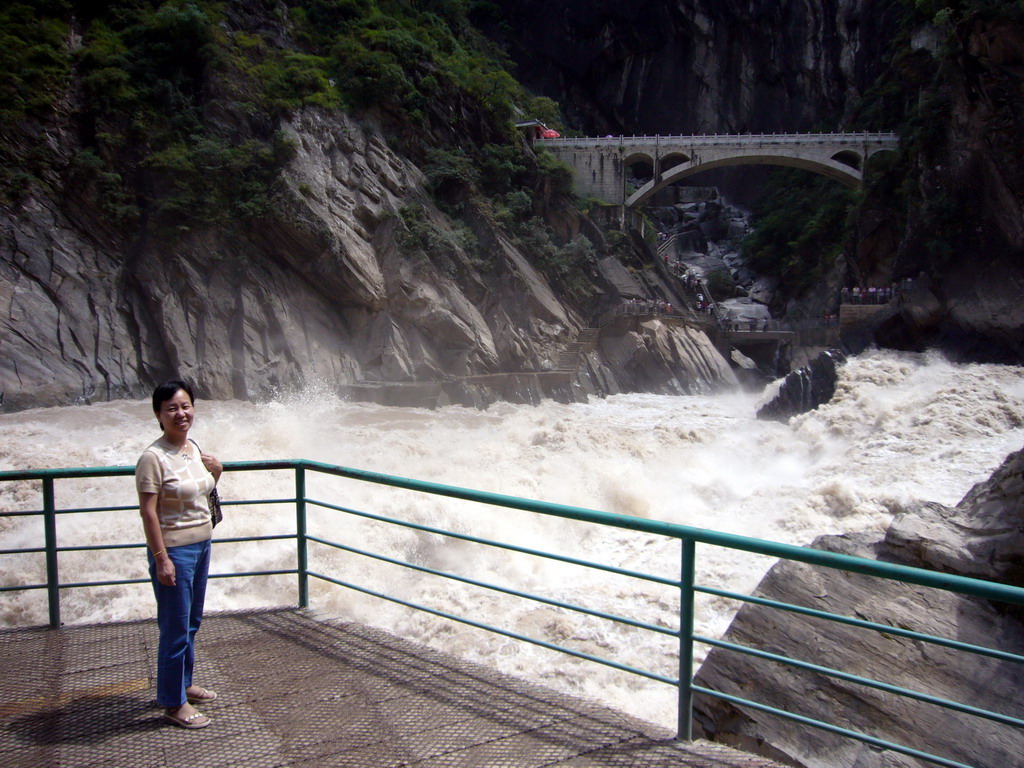 Miaomiao`s mother at the rapids and bridge at Tiger Leaping Gorge