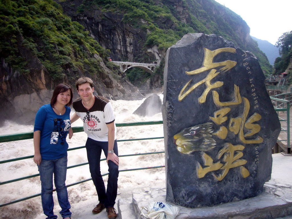 Tim and Miaomiao with monument stone at Tiger Leaping Gorge
