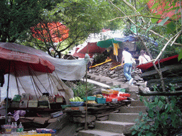 Track with small shops alongside, going up from Tiger Leaping Gorge