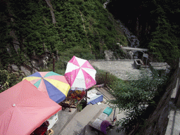 Bridge and track with small shops alongside at Tiger Leaping Gorge, viewed from the parking place