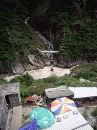 Bridge and track with small shops alongside at Tiger Leaping Gorge, viewed from the parking place