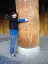 Miaomiao with a wooden pillar of a Tibetan buddhism temple