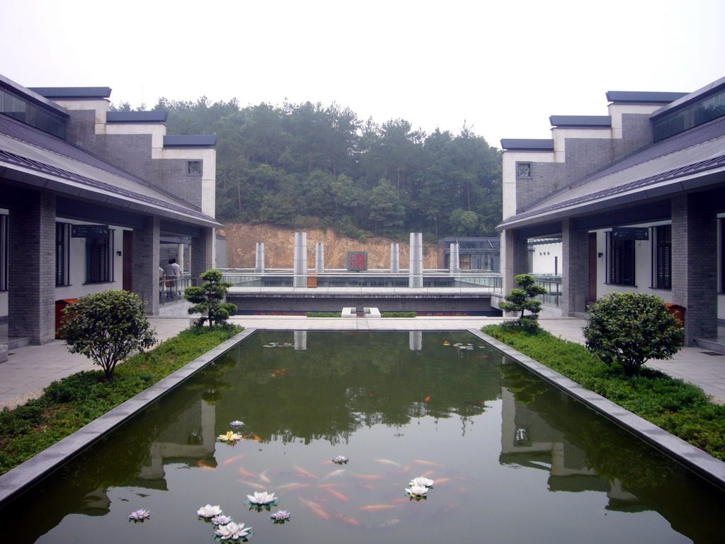 Top floor of the Shaoshan Mao Zedong Relic Museum, with a pond and a large version of Mao Zedong`s stamp