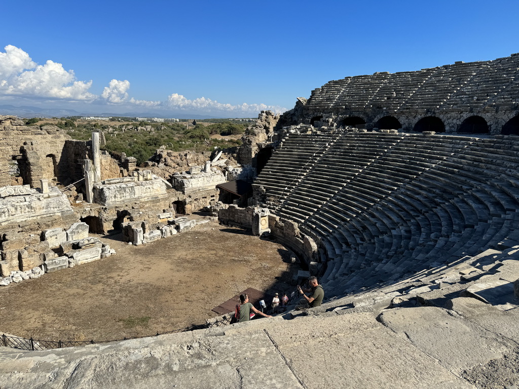Miaomiao and Max at the bottom of the southwest auditorium of the Roman Theatre of Side, with a view on the orchestra, stage and stage building, viewed from the diazoma of the west auditorium