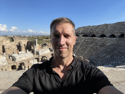 Tim at the diazoma of the west auditorium of the Roman Theatre of Side, with a view on the southeast auditorium, stage and stage building