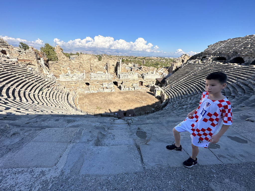 Max at the diazoma and Tim at the bottom of the southwest auditorium of the Roman Theatre of Side, with a view on the auditorium, orchestra, stage and stage building