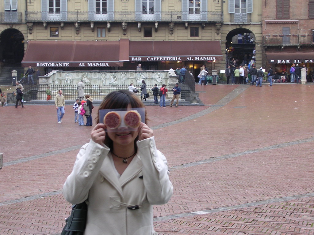 Miaomiao in front of the Gaia Fountain and the Loggia della Mercanzia building at the Piazza del Campo square