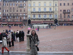 Miaomiao`s friend in front of the Gaia Fountain and the Loggia della Mercanzia building at the Piazza del Campo square