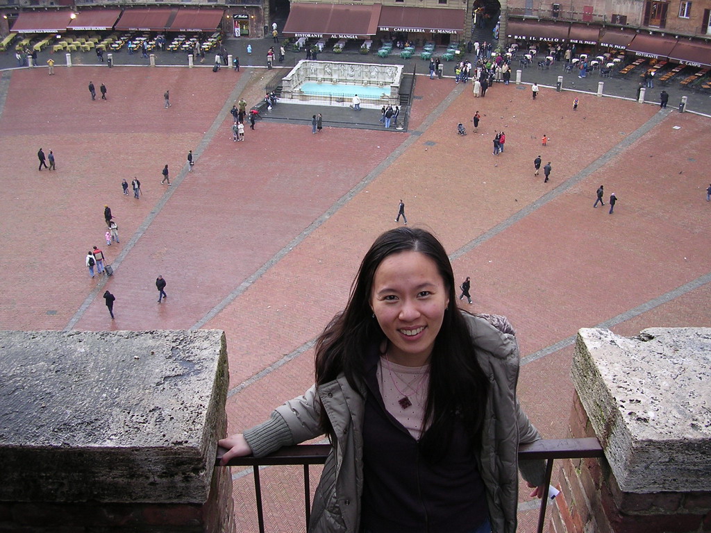 Miaomiao`s friend at the roof of the Pubblico Palace, with a view on the Piazza del Campo square with the Gaia Fountain and the Loggia della Mercanzia building
