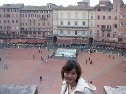 Miaomiao at the roof of the Pubblico Palace, with a view on the Piazza del Campo square with the Gaia Fountain and the Loggia della Mercanzia building
