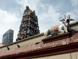 Wall with a statue of a cow and the tower above the entrance to the Sri Mariamman Temple, viewed from Pagoda Street