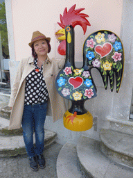 Miaomiao with a painted rooster statue at the Rua Visconde Monserrate street