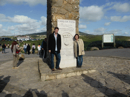 Tim and Miaomiao at the plaque with inscription `Westernmost Point of Continental Europe` at the column with cross at the Cabo da Roca cape