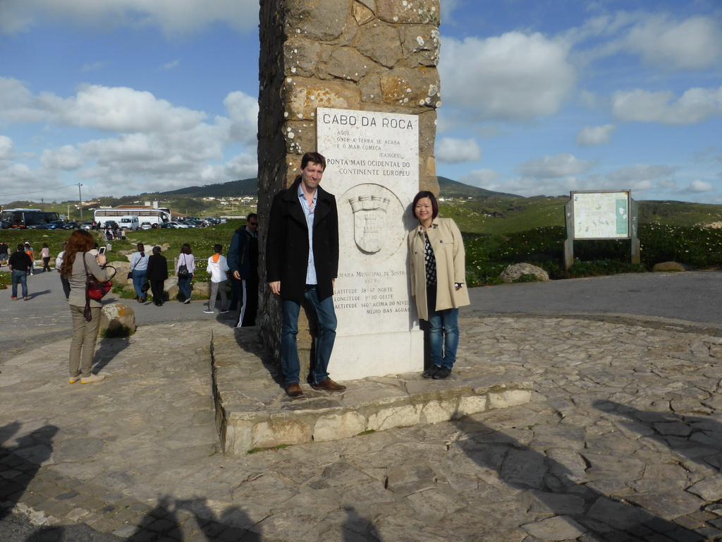 Tim and Miaomiao at the plaque with inscription `Westernmost Point of Continental Europe` at the column with cross at the Cabo da Roca cape