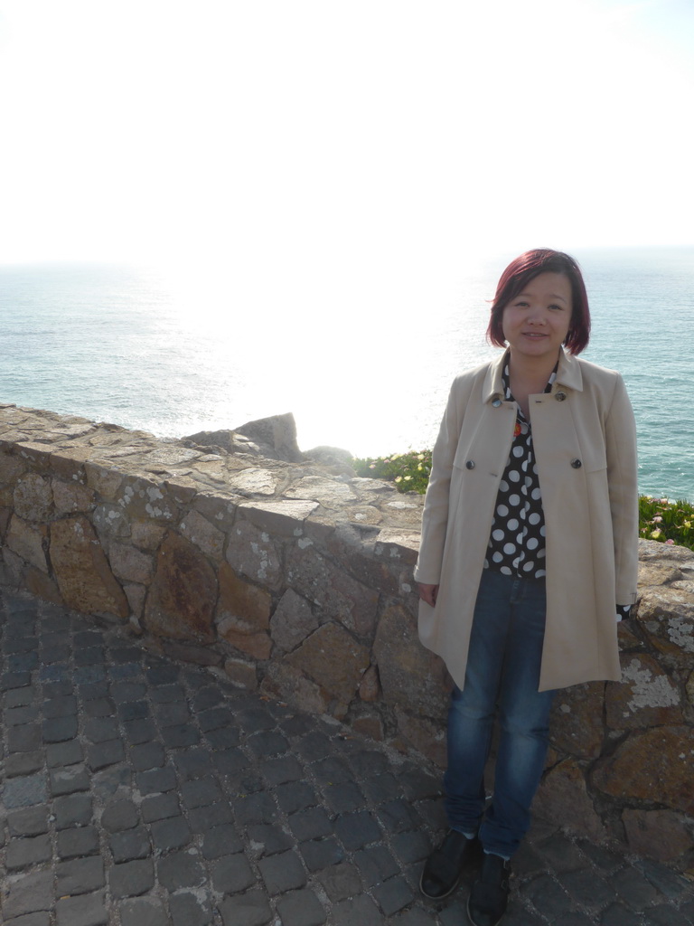 Miaomiao at the wall at the Cabo da Roca cape and the Atlantic Ocean