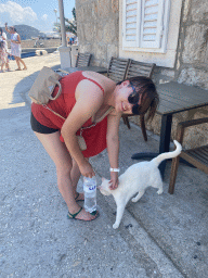 Miaomiao with a cat in front of a house at the town of Sudurad