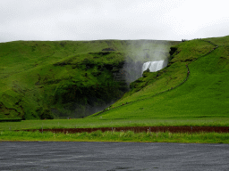 The Skógafoss waterfall with the trail and platform on the east side, viewed from the parking lot of the Fossbúð restaurant
