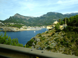 Boats in the harbour and the Faro de Punta de Sa Creu lighthouse, viewed from the rental car on the Camí del Far street