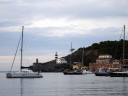 Boats in the harbour and the Faro de Punta de Sa Creu lighthouse, viewed from the east side of the Platja d`en Repic beach