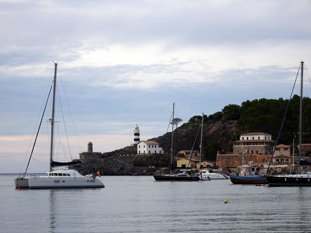 Boats in the harbour and the Faro de Punta de Sa Creu lighthouse, viewed from the east side of the Platja d`en Repic beach