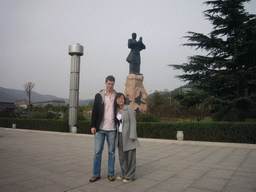 Tim and Miaomiao with statue at entrance of Shaolin Monastery