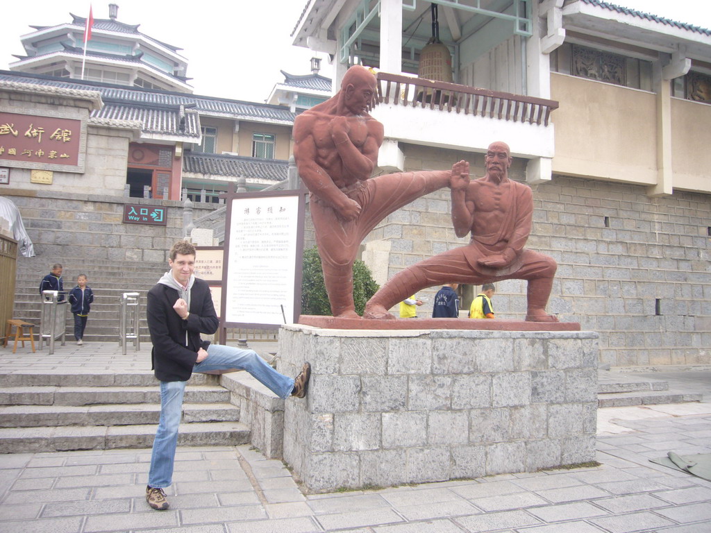 Tim with statue at the Front of Kung Fu Academy near Shaolin Monastery