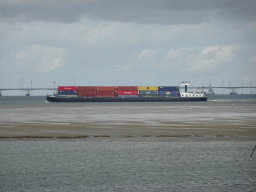 Boat on the National Park Oosterschelde and the Zeelandbrug bridge, viewed from the beach near the Dijkweg road