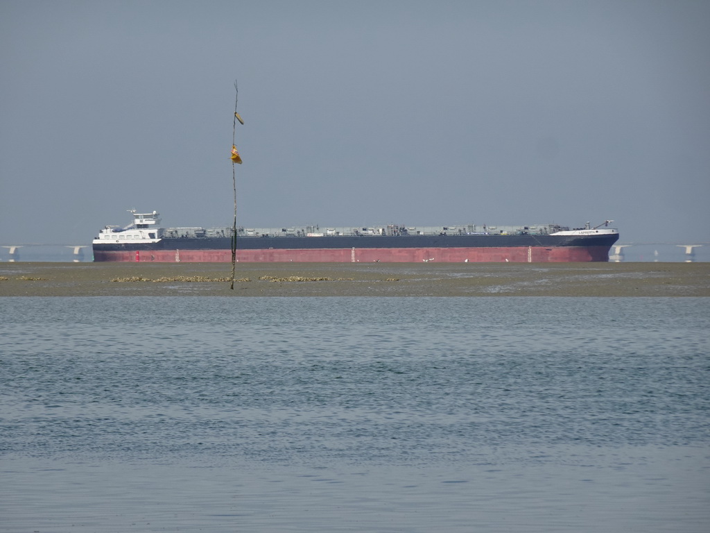 Boat at the National Park Oosterschelde and the Zeelandbrug bridge, viewed from the beach near the Dijkweg road