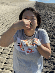 Miaomiao eating an oyster at the beach near the Dijkweg road