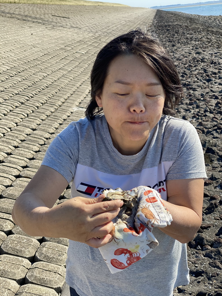 Miaomiao eating an oyster at the beach near the Dijkweg road