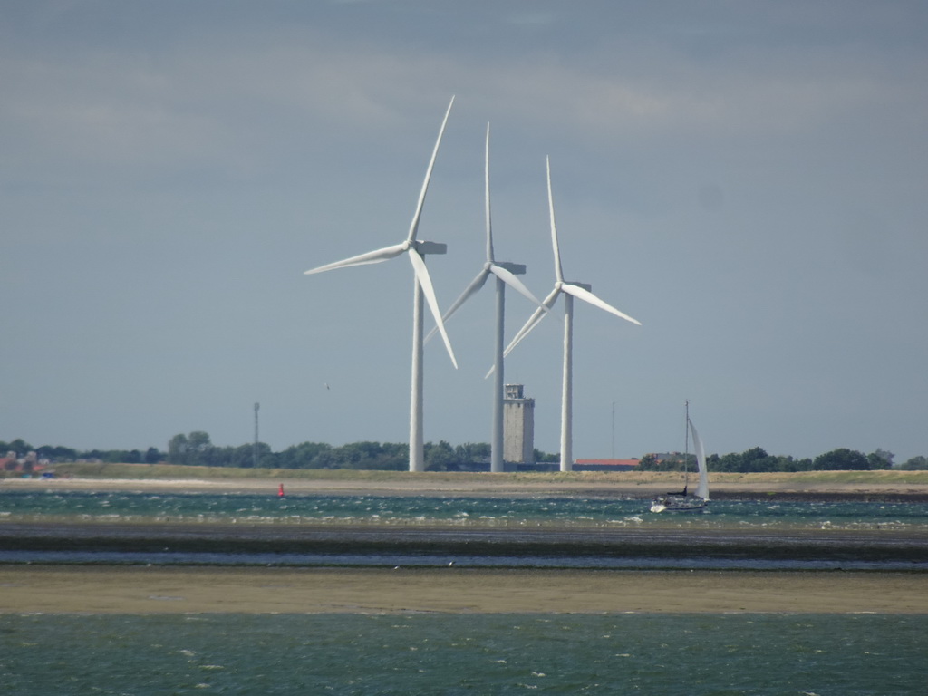Windmills and boat at the National Park Oosterschelde, viewed from the beach near the Dijkweg road