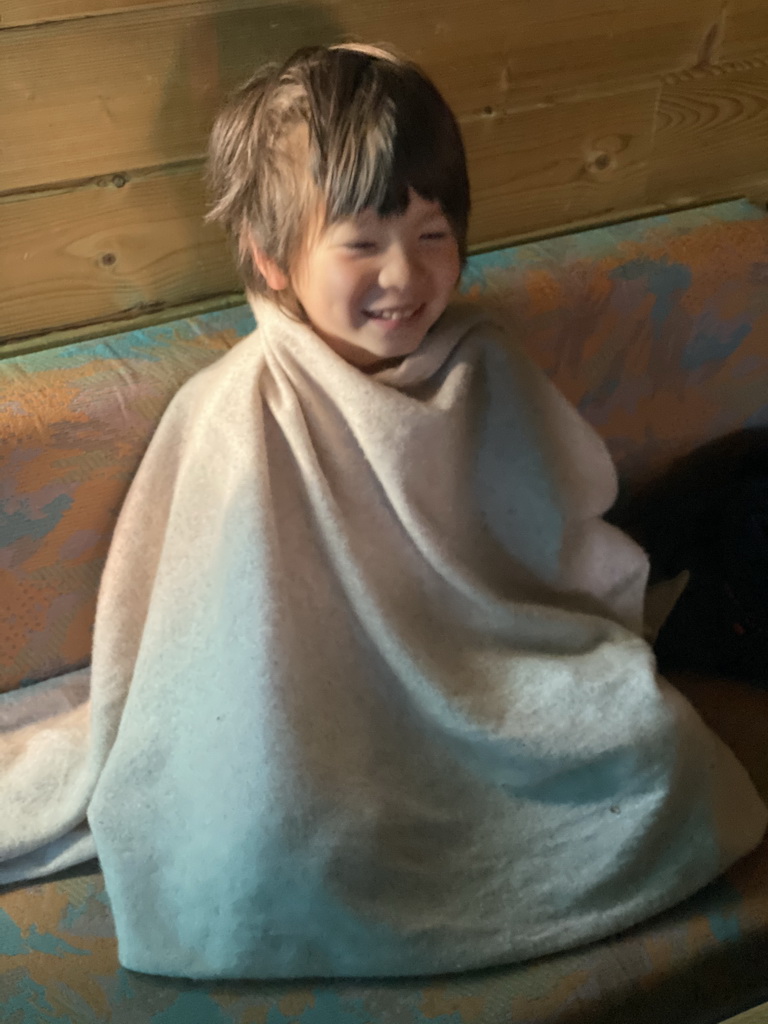 Max wrapped in a blanket in the living room of the Stuurhut holiday home at the Oosterschelde Camping Stavenisse