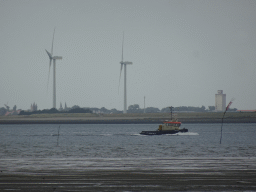 Boat on the National Park Oosterschelde, windmills and the city center of Zierikzee, viewed from the beach near the Dijkweg road