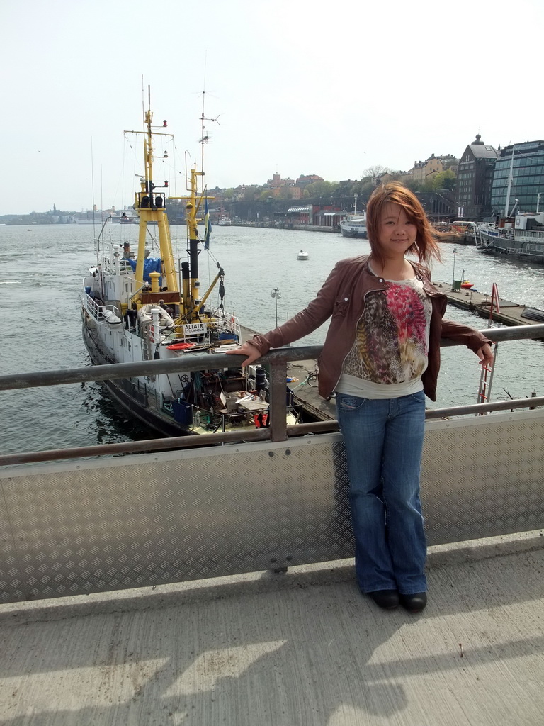 Miaomiao on the Skeppsbron bridge with a view on the Söderström river and the shore of the Södermalm neighborhood