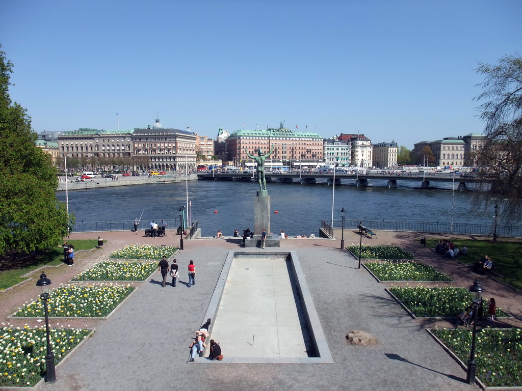 Park with statue in front of the Museum of Medieval Stockholm (Stockholms medeltidsmuseum), and the Strömbron bridge over the Norrström river