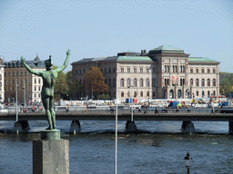 Statue in the park in front of the Museum of Medieval Stockholm, the Strömbron bridge over the Norrström river and the National Museum