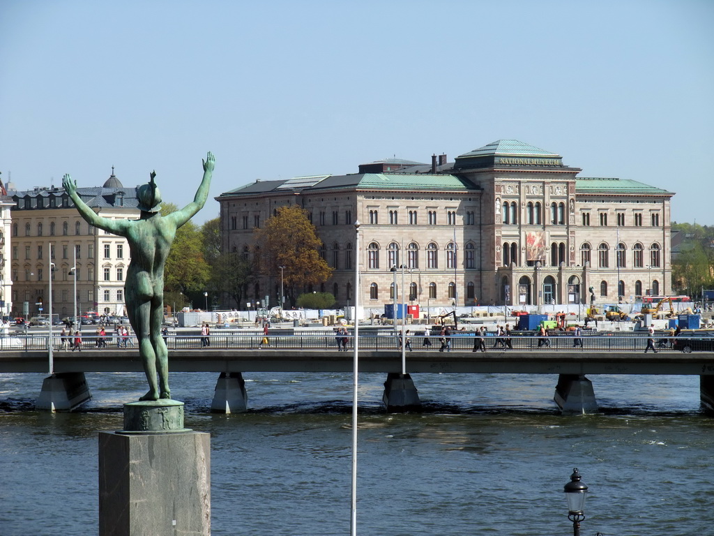Statue in the park in front of the Museum of Medieval Stockholm, the Strömbron bridge over the Norrström river and the National Museum
