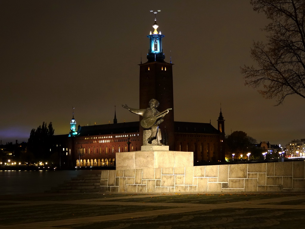 Statue of Evert Taube at the Evert Taubes Terrass park and the Stockholm City Hall, by night